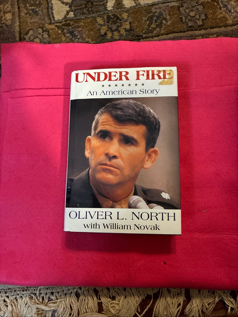 Under Fire: An American Story by Oliver L. North - Book with Pink Background